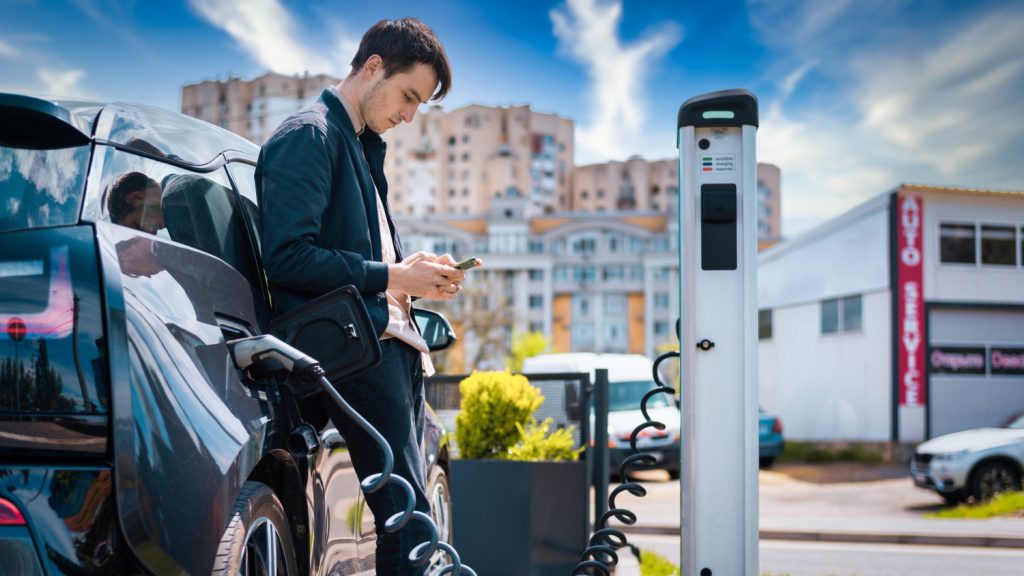 man-charging-his-electric-car-charge-station-using-smartphone